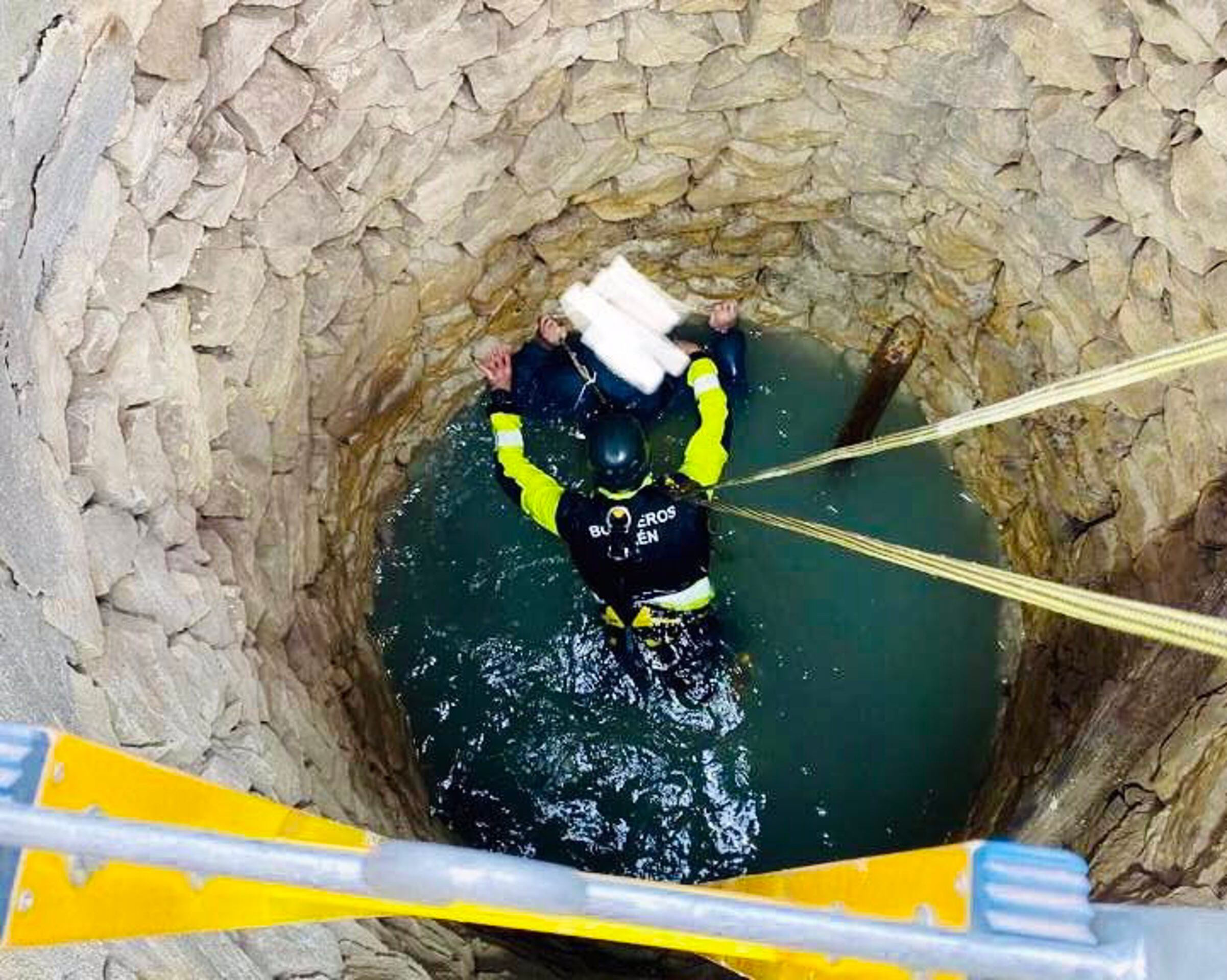 Bomberos de rescatando al hombre que había caído al pozo.
