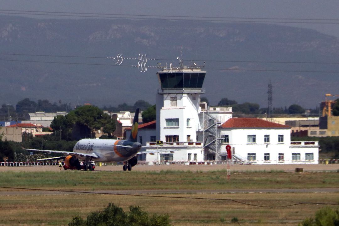 Pla obert de la torre de control de l&#039;Aeroport de Reus i un avió de Thomas Cook estacionat a l&#039;aparcament.