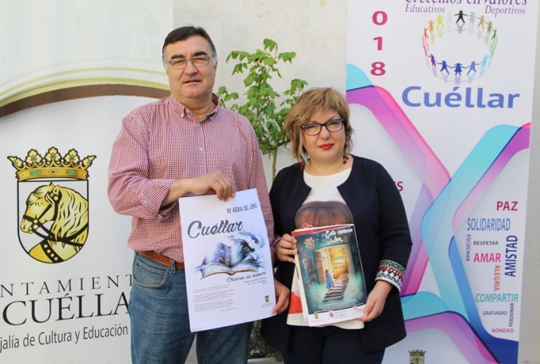 Los concejales de Cultura, Sonia Martín y Patrimonio, Luis Senovilla, muestran los carteles de la Feria del Libro de Cuéllar