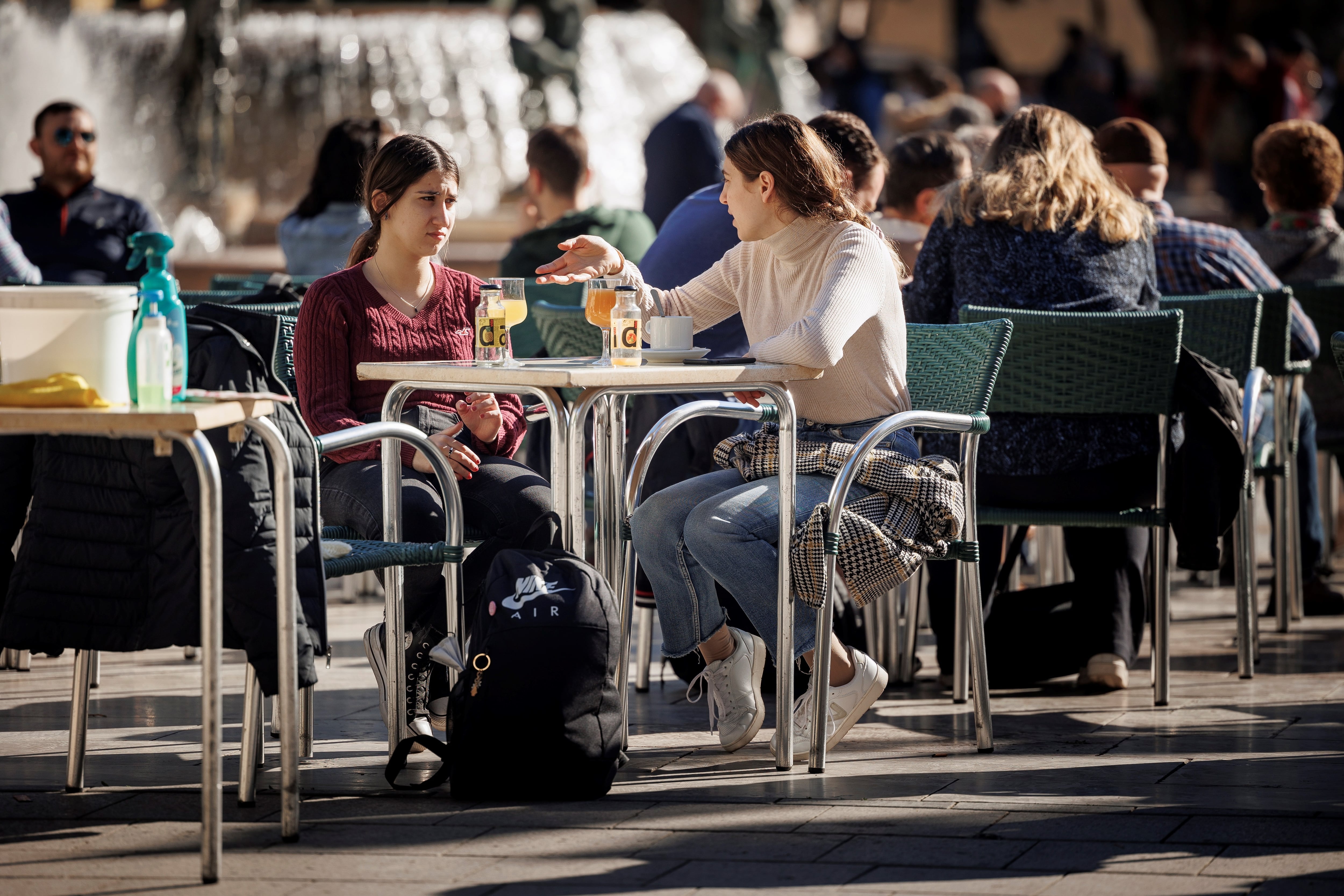 Varias personas disfrutan de un soleado día de invierno en una terraza