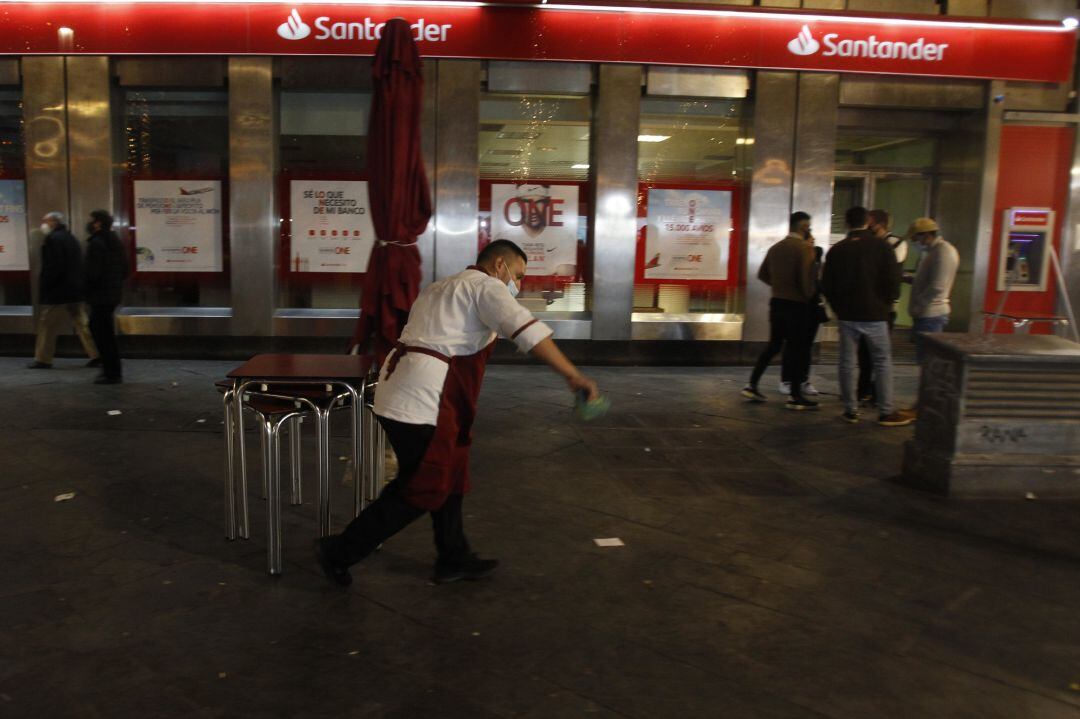 Archivo - Un camarero recoge las mesas de la terraza de un bar en Palma
