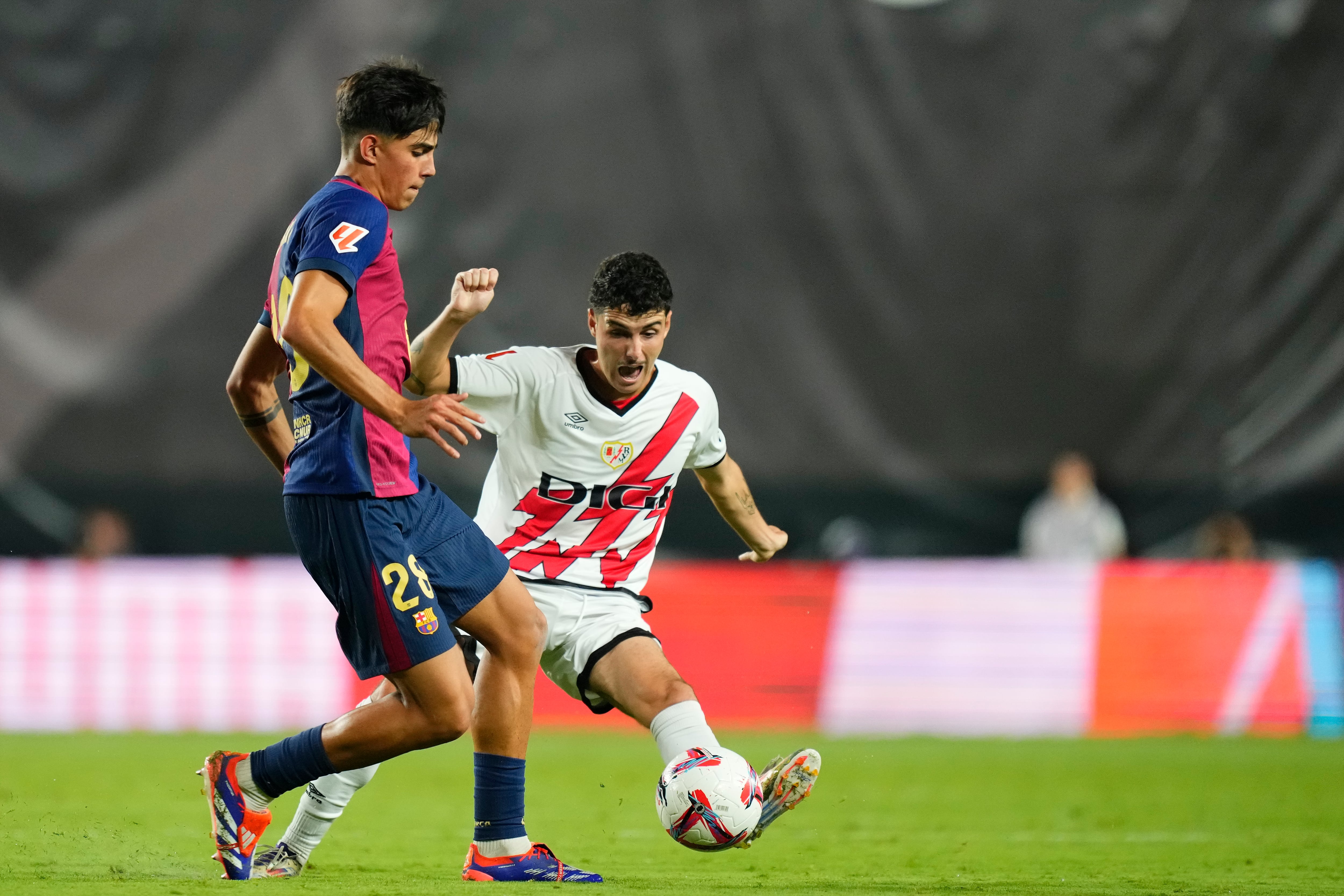 Sergio Camello intenta robar el balón a Marc Bernal durante el partido entre el Rayo y el Barcelona