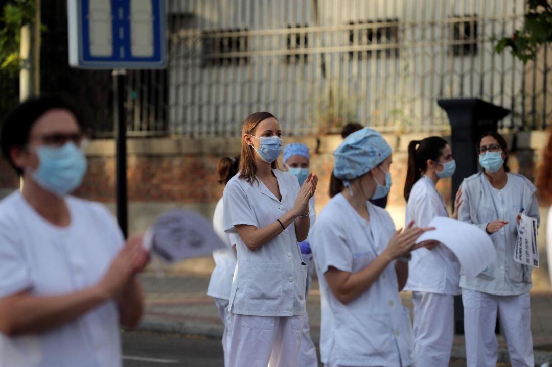 Miembros del personal sanitario aplaudiendo ala entrada de un hospital. 