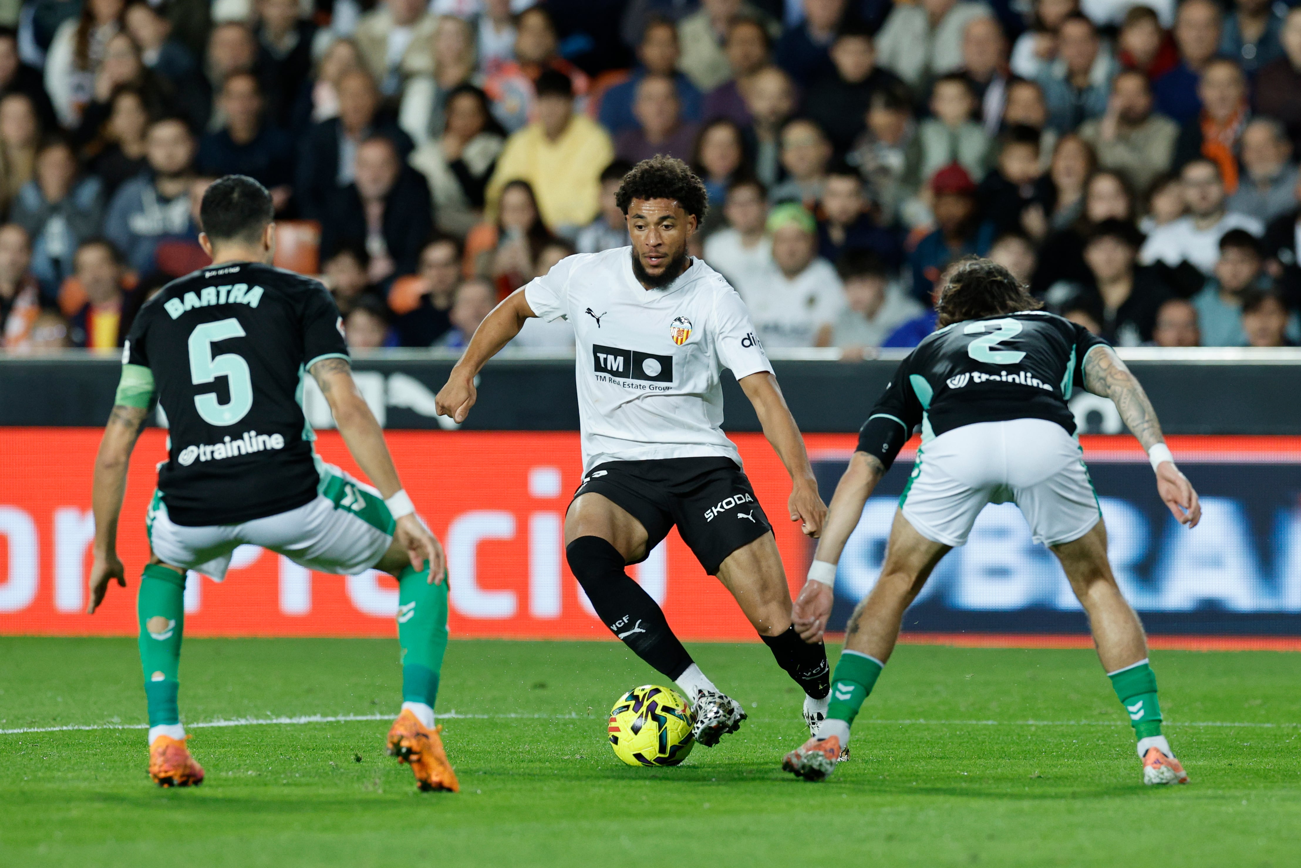 VALENCIA, 09/11/2025.- El delantero del Valencia Arnaut Danjuma (c) ante la defensa de Bartra y Héctor Bellerín (d) del Betis durante el partido de la jornada 12 de LaLiga EA Sports que Valencia CF y Real Betis disputan este domingo, en el Estadio de Mestalla. EFE/ Kai Försterling
