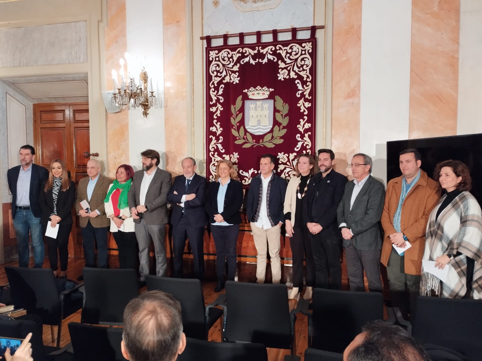 La corporación municipal, junto con el presidente de la RSD Alcalá, José Antonio Pareja, y el presidente de la RFFM, Paco Díez, durante la presentación de los actos conmemorativos del centenario de la RSD Alcalá en el Salón de Plenos del Ayuntamiento de Alcalá de Henares