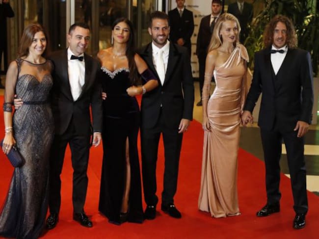 Xavi Hernández, Cesc Fàbregas y Carles Puyol, con sus parejas, posan ante la prensa