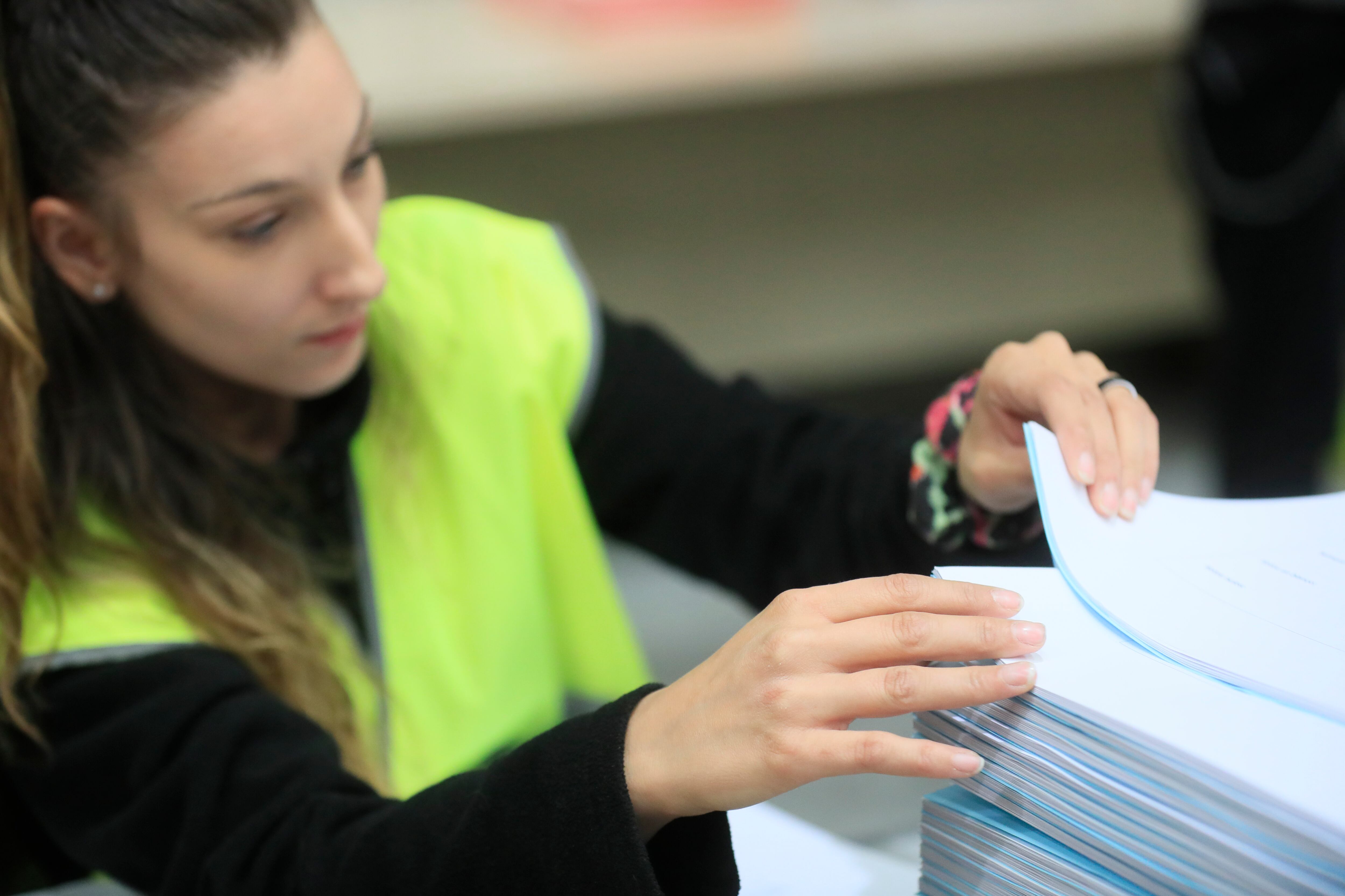 ALCALÁ DE HENARES (MADRID), 12/05/2023.- Una trabajadora clasifica material para las próximas elecciones del 28 de mayo en Madrid en el centro logístico electoral de la Delegación del Gobierno, que sirve de almacén electoral y archivo de documentación, este viernes en el polígono de La Garena de Alcalá de Henares. EFE/ Fernando Alvarado