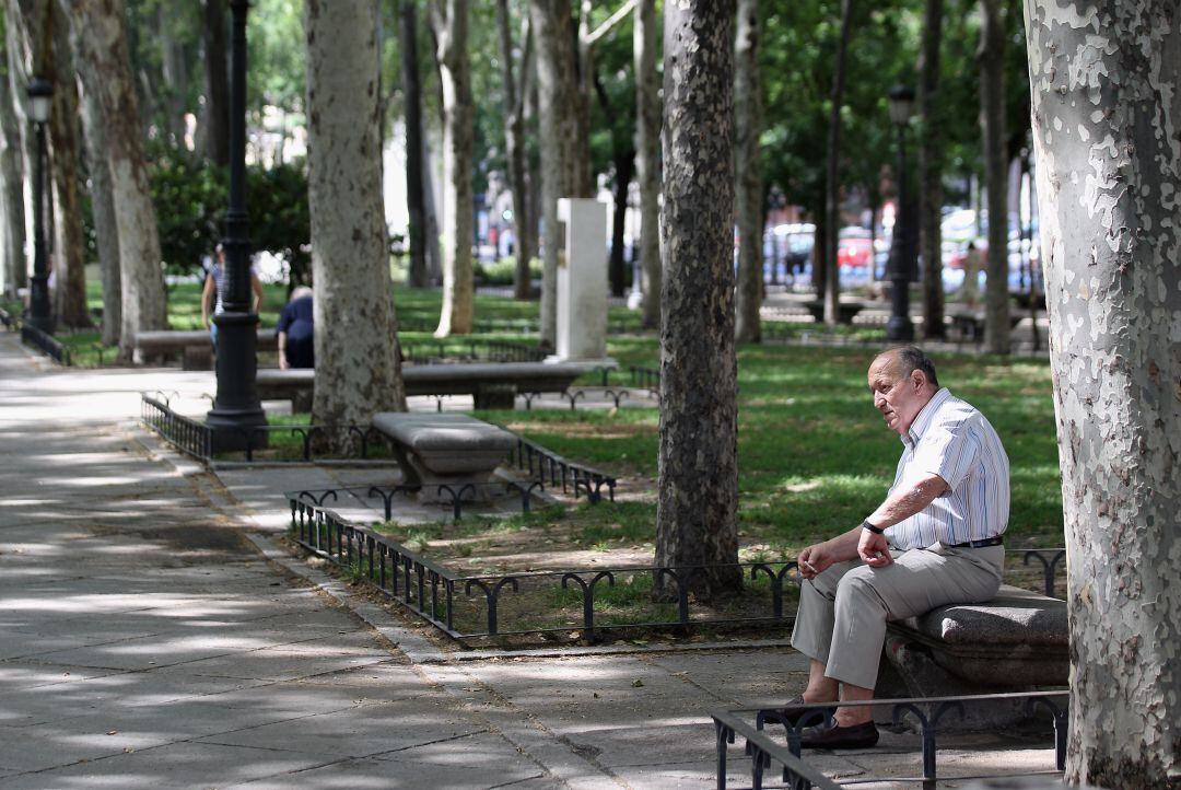 Un hombre sentado en el Paseo del Prado, en pleno centro de la capital 