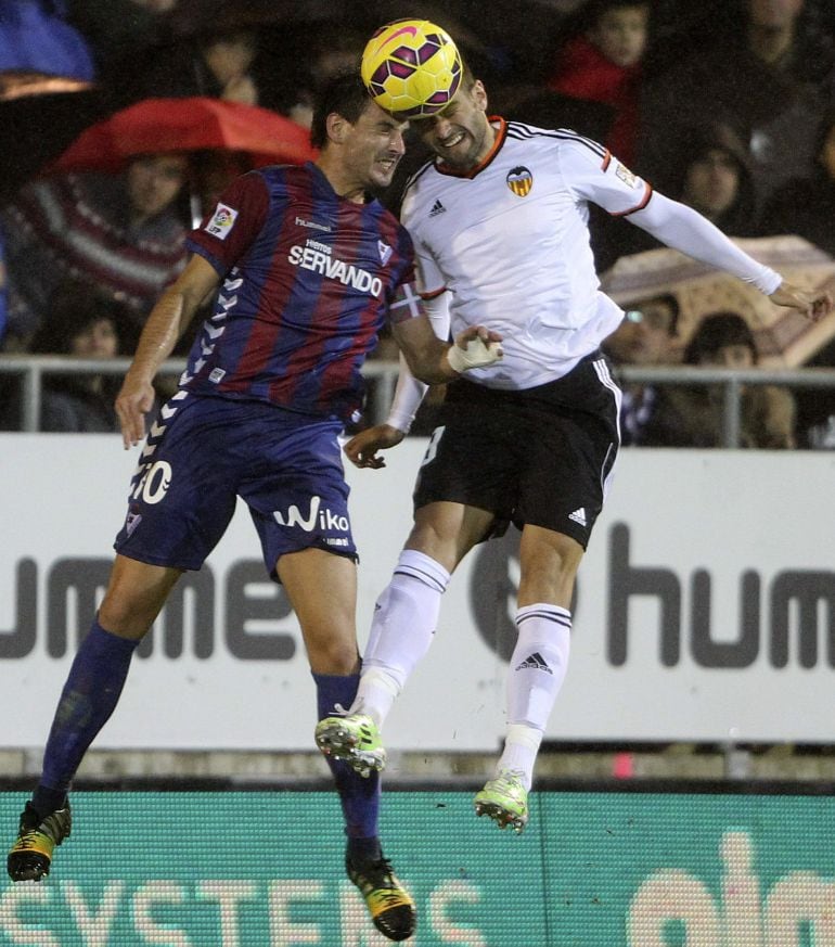 GRA278. EIBAR (GIPUZKOA), 20/12/2014.- El jugador del Eibar Arruabarrena (i) salta a por un balón con Barragán, del Valencia, durante el partido de Liga en Primera División disputado esta noche en el estadio de Ipurúa, en Eibar. EFE/Juan Herrero