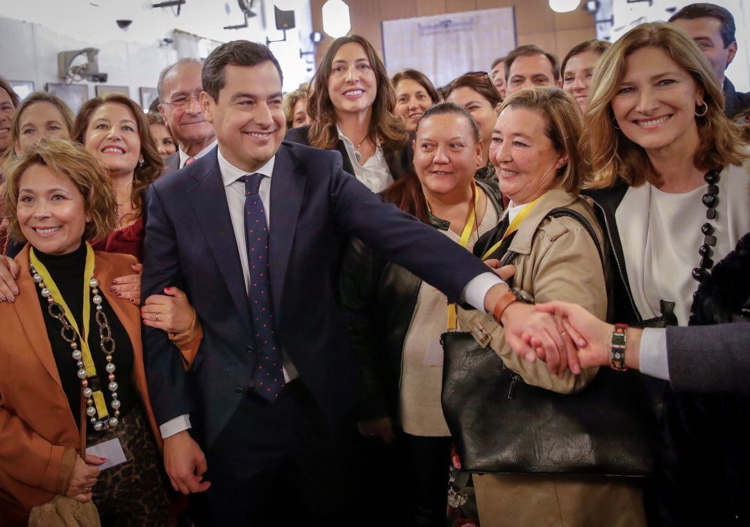 El líder del PP-A, Juanma Moreno (c), es felicitado por militantes y simpatizantes de su partido tras su intervención en el debate de investidura 