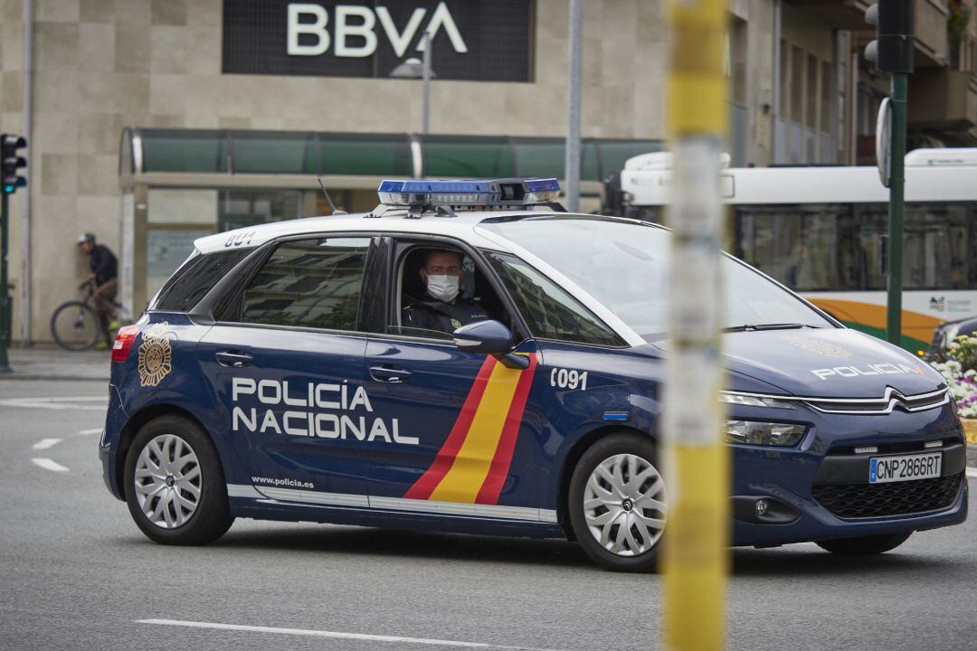 Un vehículo de la Policía Nacional patrulla por una céntrica calle de Málaga