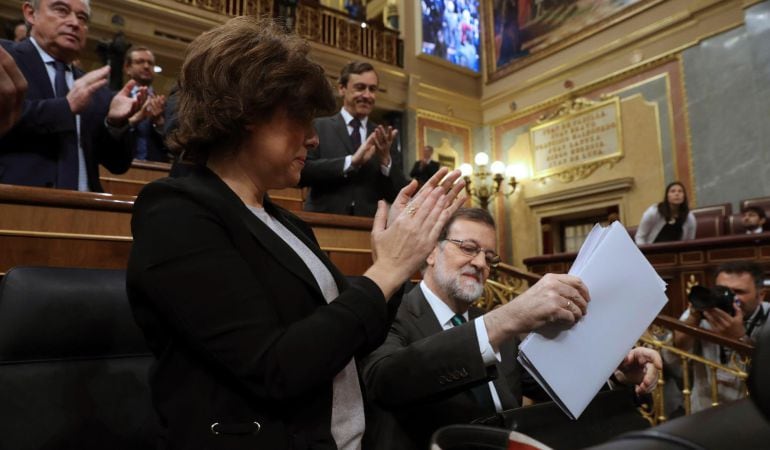 El presidente del Ejecutivo, Mariano Rajoy (d), junto a la vicepresidenta, Soraya Sáenz de Santamaría, durante la primera jornada de la moción de censura presentada por el PSOE contra el Gobierno.