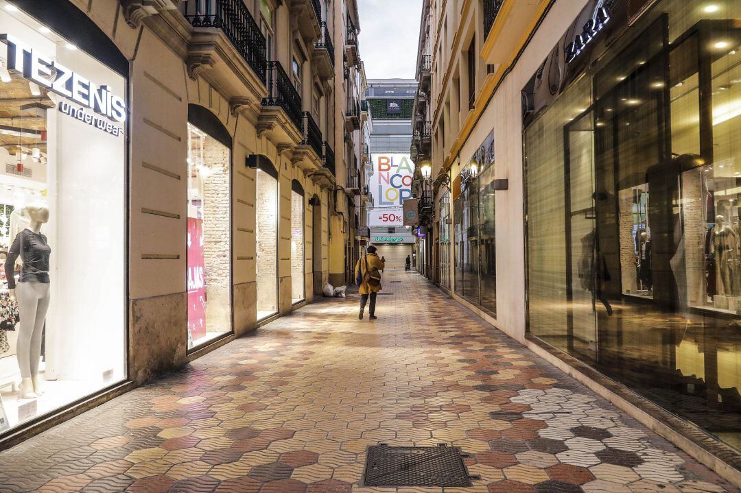 Una calle comercial de Valencia con todos sus establecimiento cerrados el primer día del cierre total de la hostelería y de tiendas a las 18.00h en València.