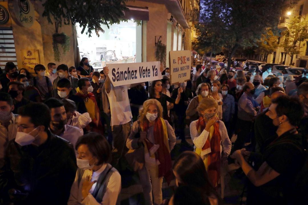 Decenas de madrileños participan este viernes, frente a la sede del PSOE en la madrileña calle Ferraz, en una concentración contra el Gobierno tras decretar hoy el estado de alarma en Madrid para poder mantener el confinamiento perimetral.