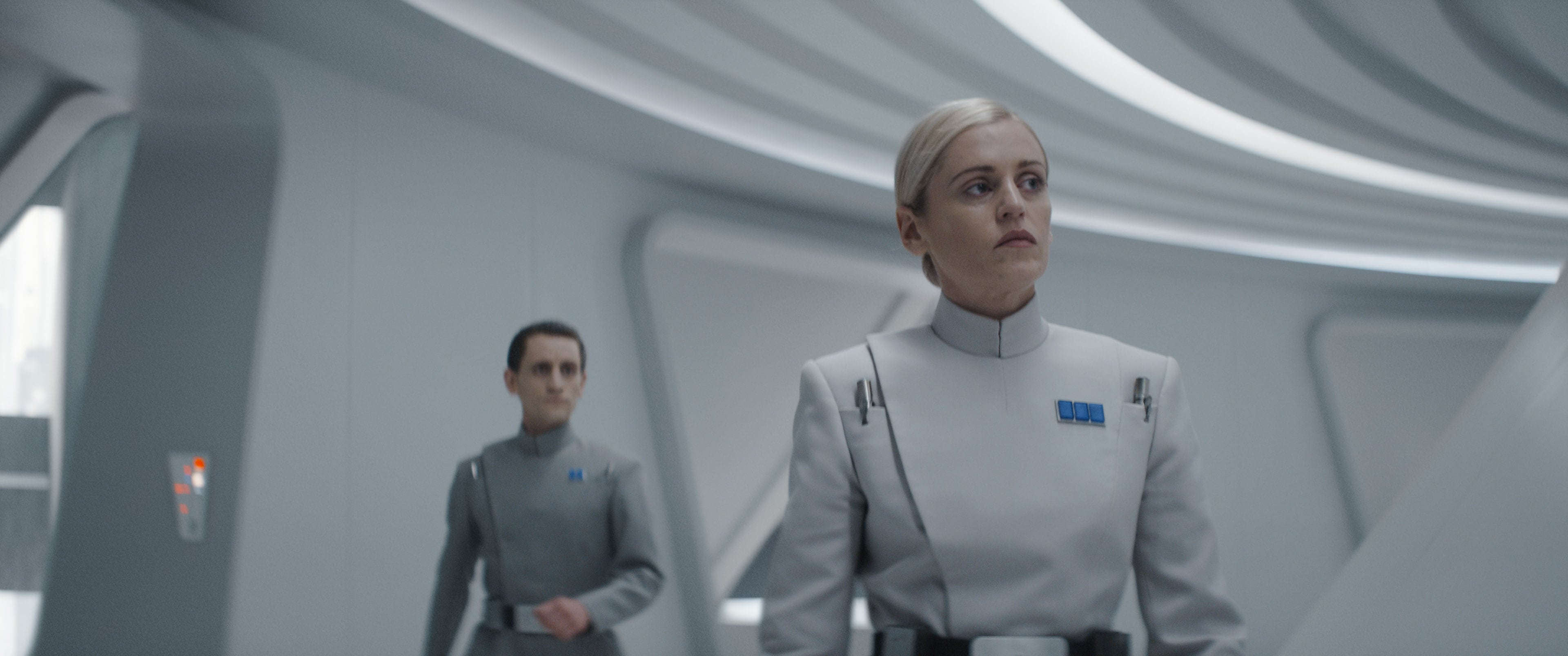 (L-R): Attendant Heert (Jacob James Beswick) and Supervisor Dedra Meero (Denise Gough) in Lucasfilm&#039;s ANDOR, exclusively on Disney+. ©2022 Lucasfilm Ltd. & TM. All Rights Reserved.