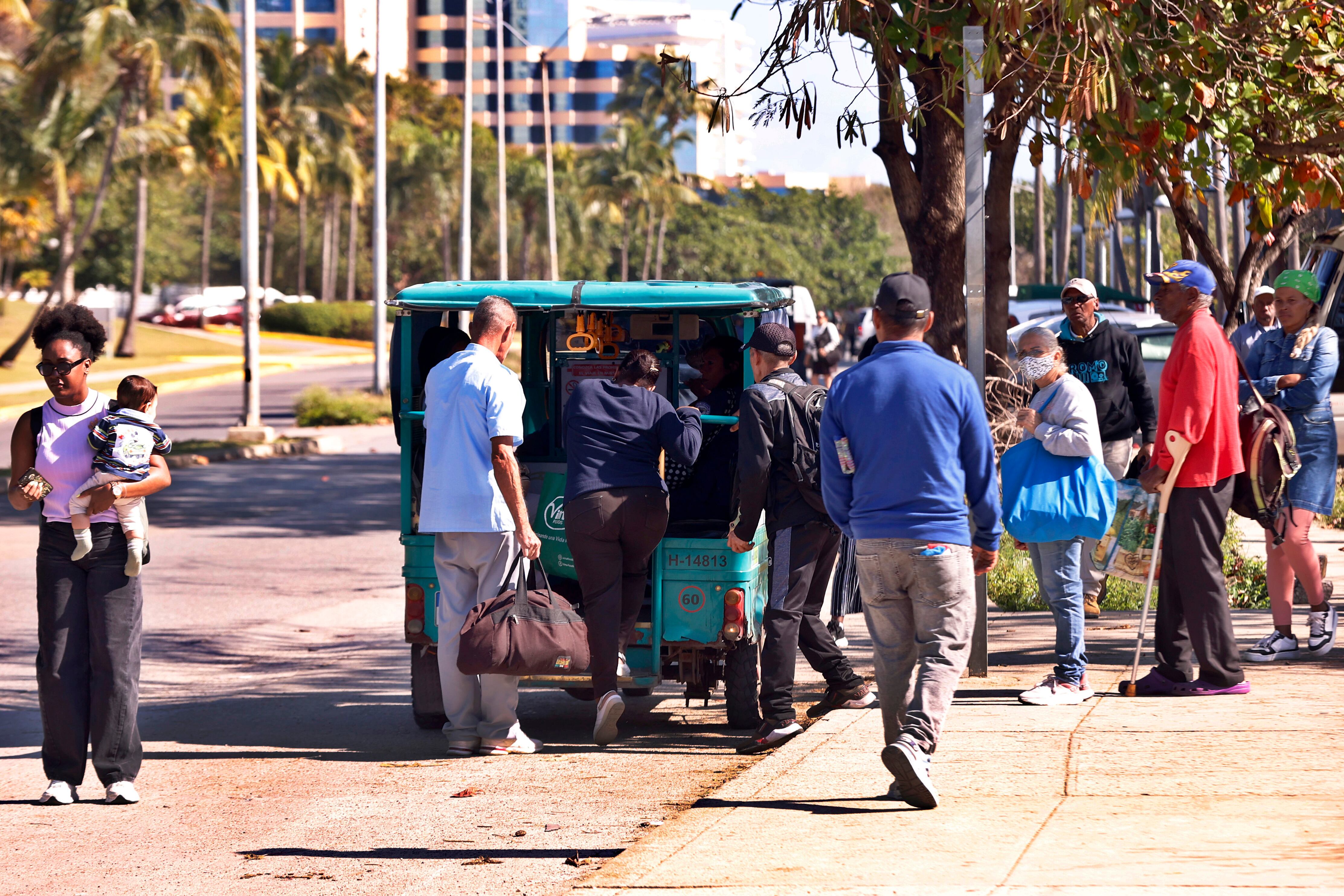 Personas suben a un vehículo eléctrico este lunes, en La Habana (Cuba).