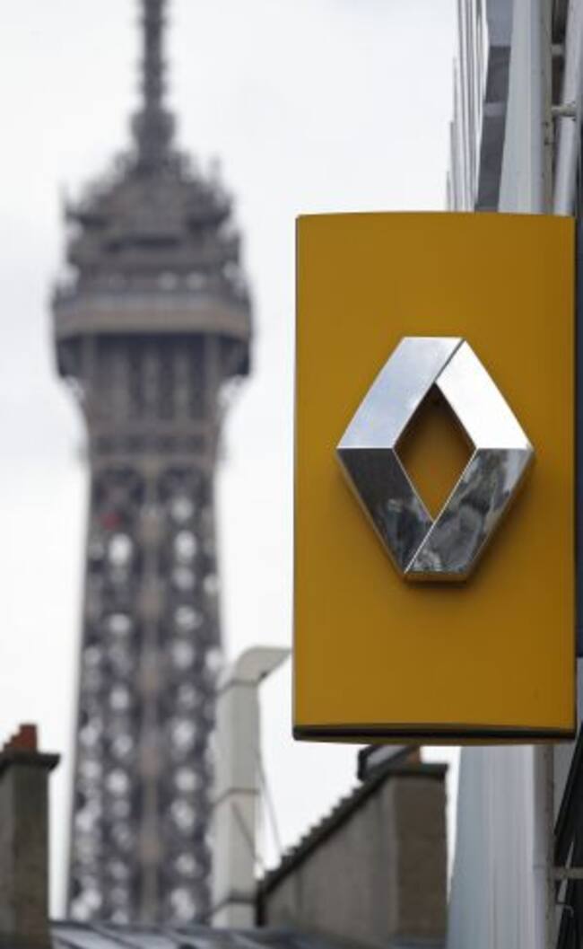 The logo of French car manufacturer Renault is seen in front of an advertisement at a dealership in Paris, November 13, 2015. REUTERS/Christian Hartmann