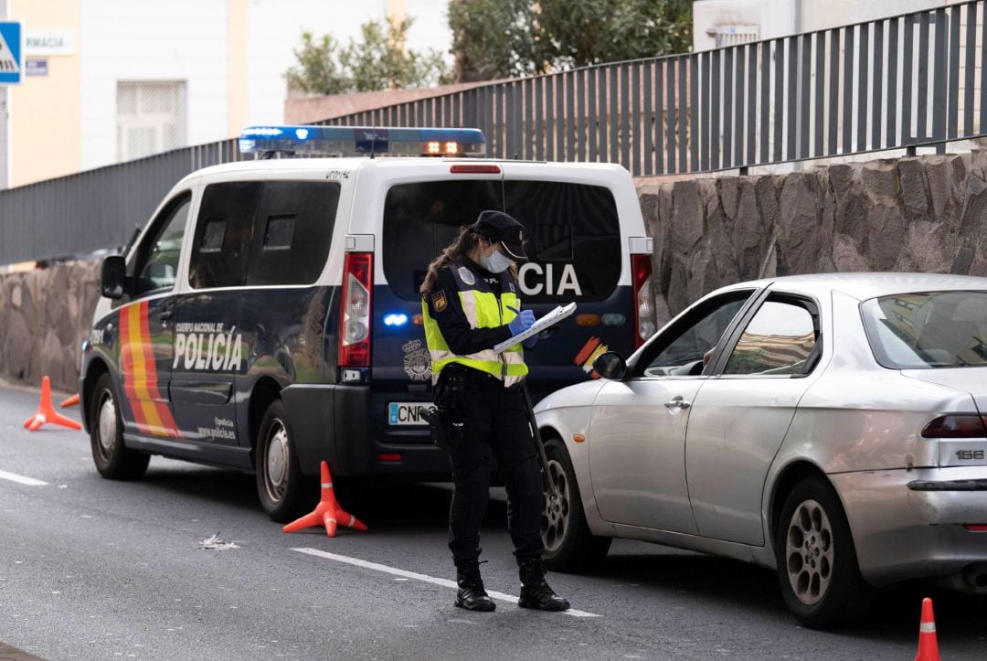 La policía nacional multa a un vehículo que se ha saltado el confinamiento decretado por el estado de alarma para frenar la expansión del coronavirus.