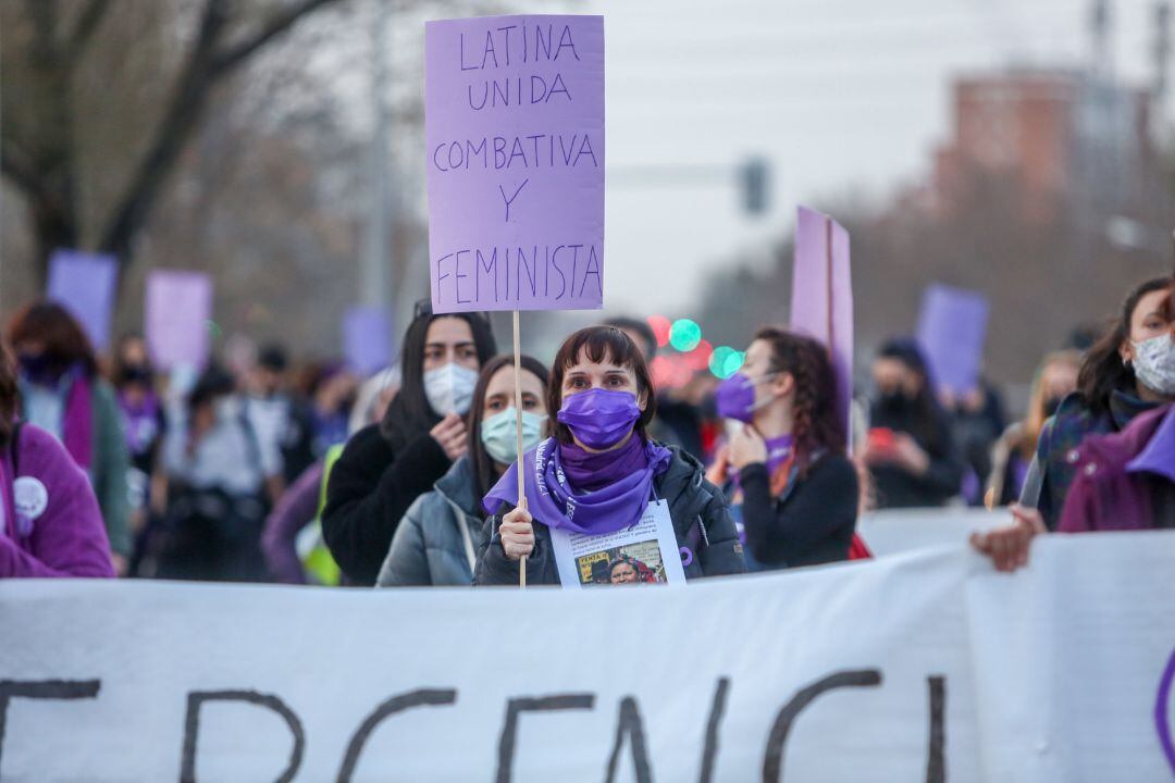 Una mujer sujeta un cartel en el que se lee: Latina, unida, combativa y feminista´ durante una marcha y batukada feminista en el CIE de Aluche, en Madrid, a 5 de marzo de 2021.