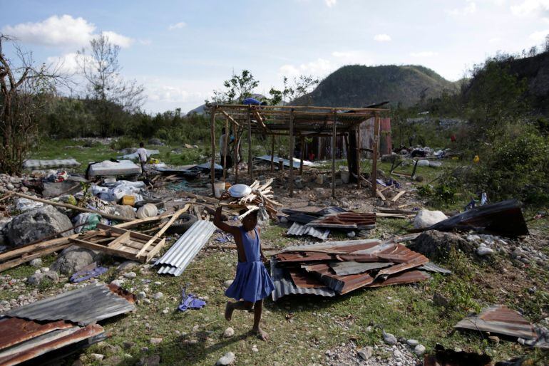 A girl carrying wood walks next to debris after Hurricane Matthew in Camp Perrin Haiti October 8 2016 REUTERS Andres Martinez Casares