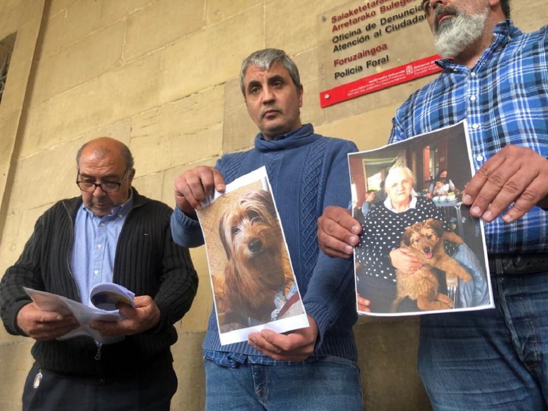 Marido e hijos de Gumersinda mostrando las fotos del perro y Gumersinda