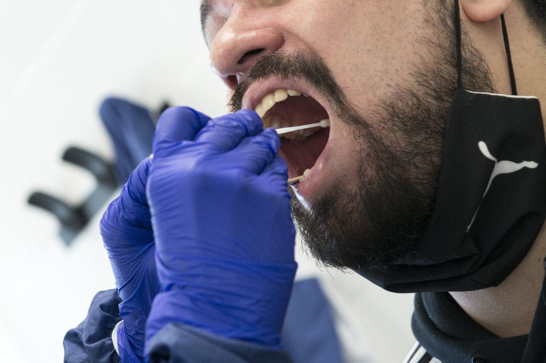 Un trabajador sanitario realiza un test PCR a un ciudadano.