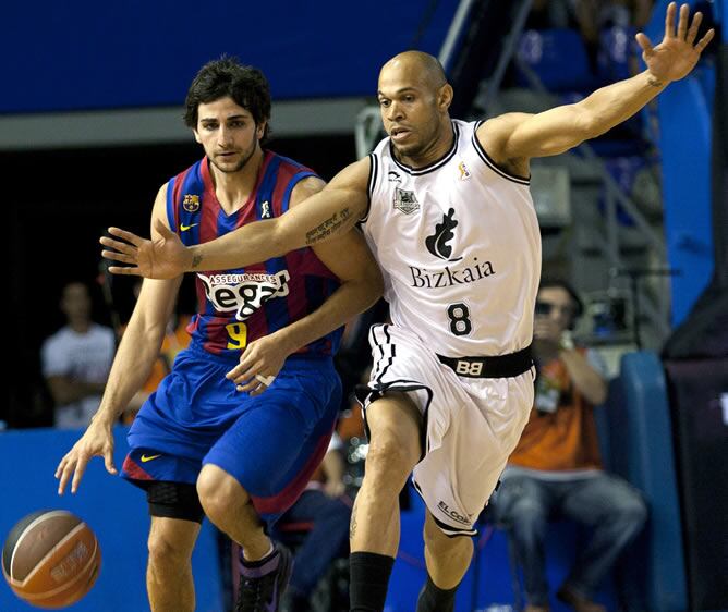 El base del Regal F.C. Barcelona Ricky Rubio intenta superar la defensa del base estadounidense con pasaporte español del Bizkaia Bilbao Basket, Josh Fisher, durante el segundo encuentro de la final de la Liga ACB de baloncesto