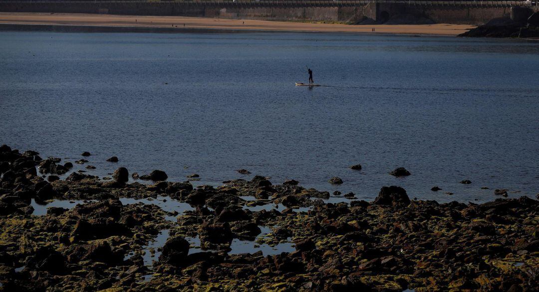 Un hombre practica paddle surf en la playa de La Concha de San Sebastián. 