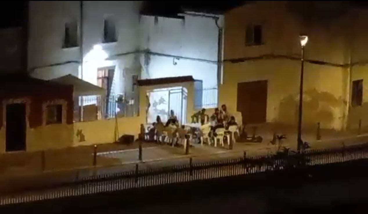 Un grupo de vecinos bailando y hablando a un alto volumen en la calle Barranco de Beniopa.