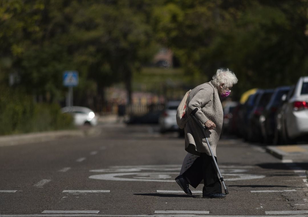 Una mujer cruza una calle perteneciente a una de las zonas básicas de salud confinadas en la Comunidad de Madrid, en una imagen de archivo