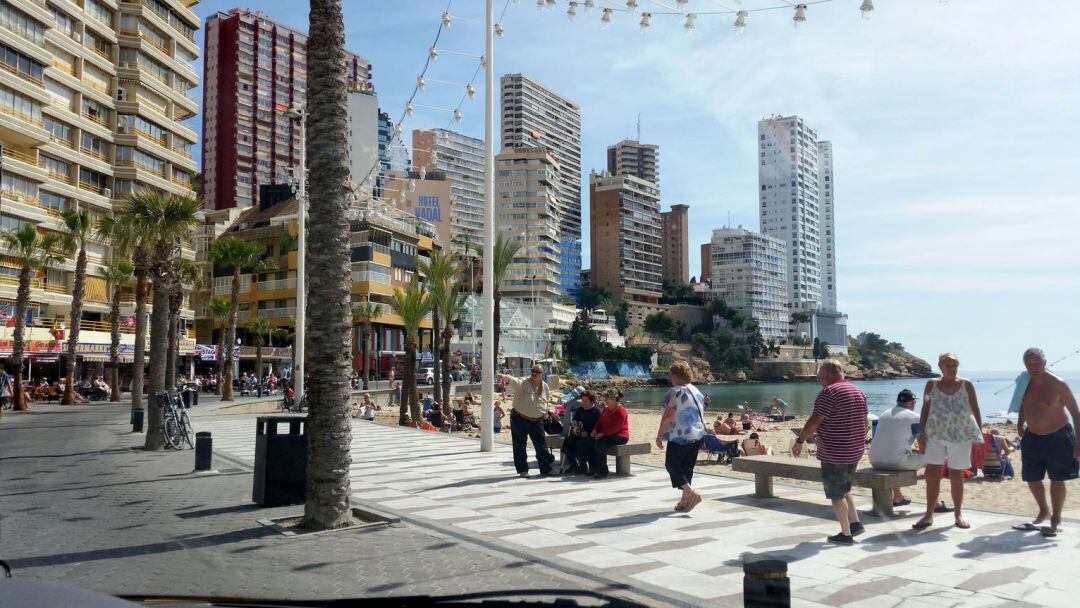 Turistas del IMSERSO, paseando por la playa en Benidorm.