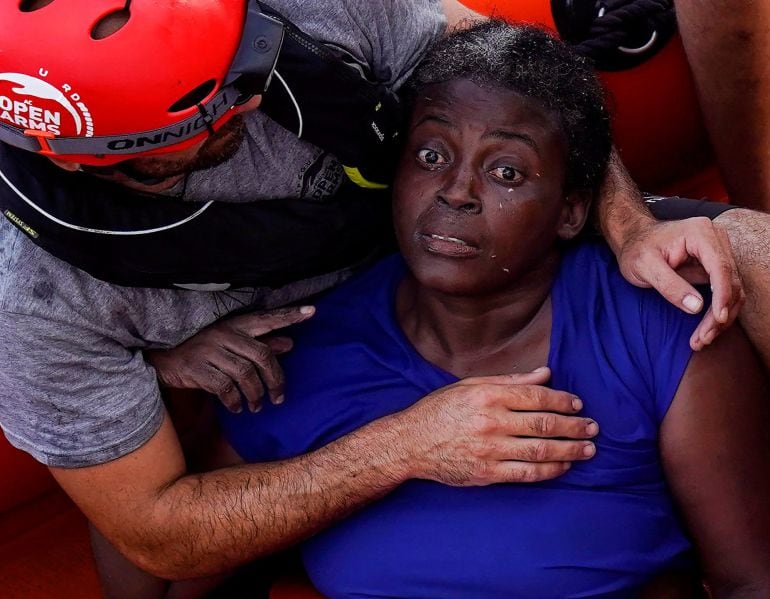 FOTOGALERÍA | Un miembro de la tripulación de Proactiva Open Arms abraza a la mujer rescatada con vida en el Mediterráneo