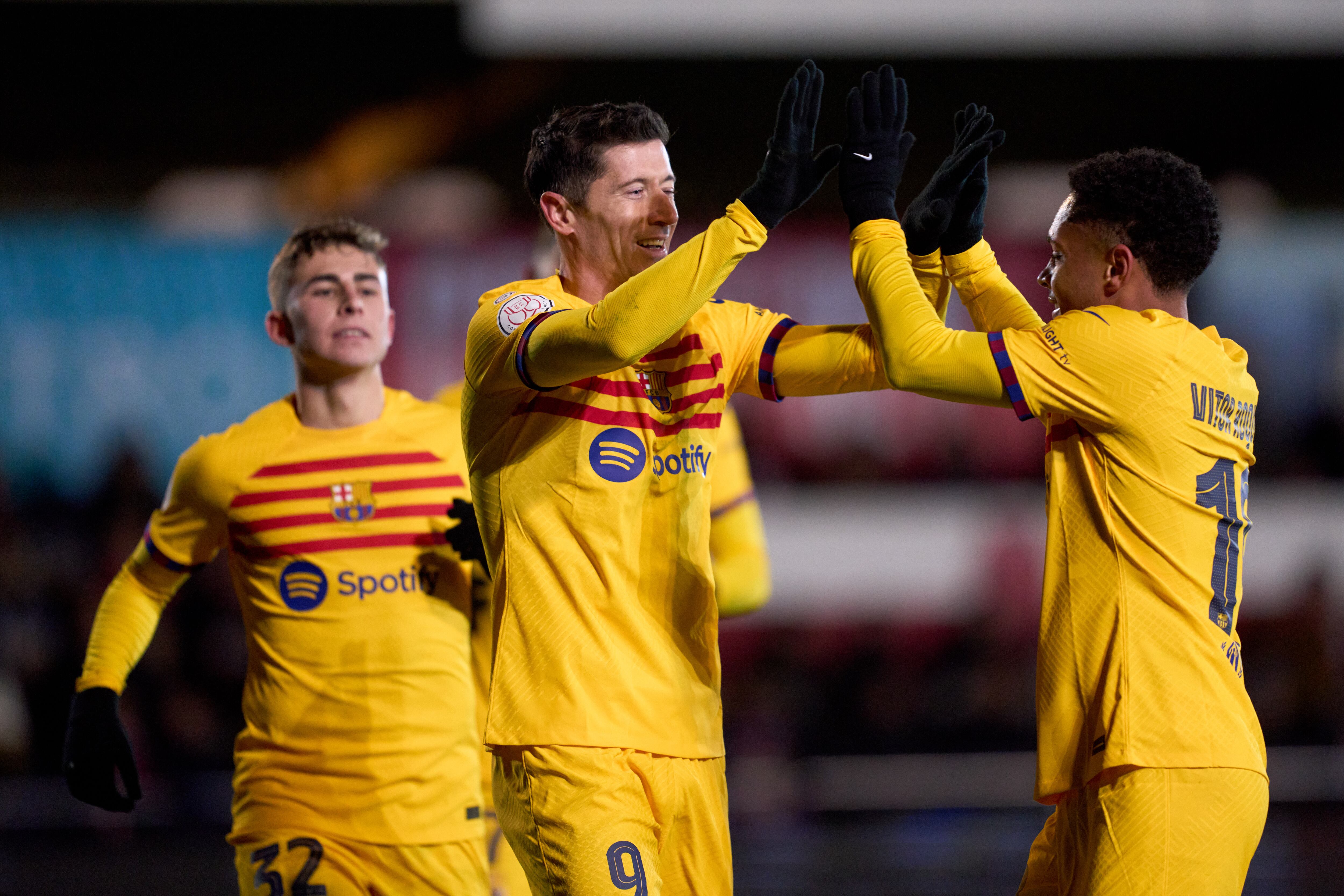 BARBASTRO, SPAIN - JANUARY 07: Robert Lewandowski of FC Barcelona celebrates with his teammate Vitor Roque after scoring their team's third goal with a penalty kick during the Copa del Rey Round of 32 match between UD Barbastro and FC Barcelona at Campo Municipal de Deportes on January 07, 2024 in Barbastro, Spain. (Photo by Alex Caparros/Getty Images)