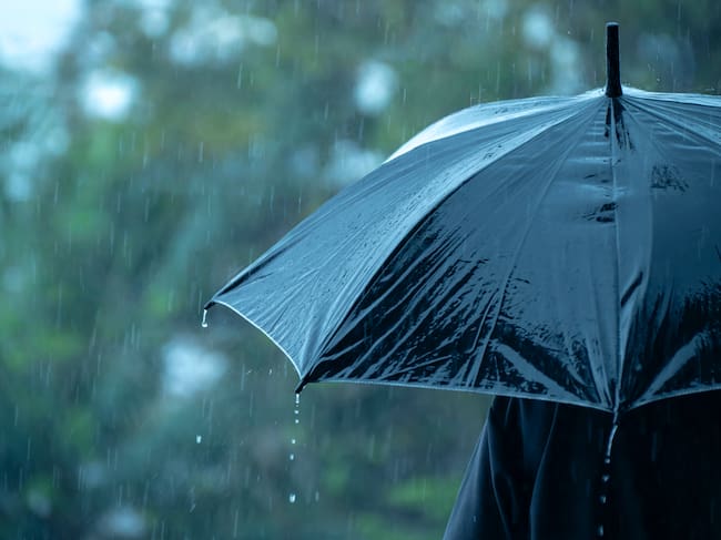 Una persona caminando bajo la lluvia.