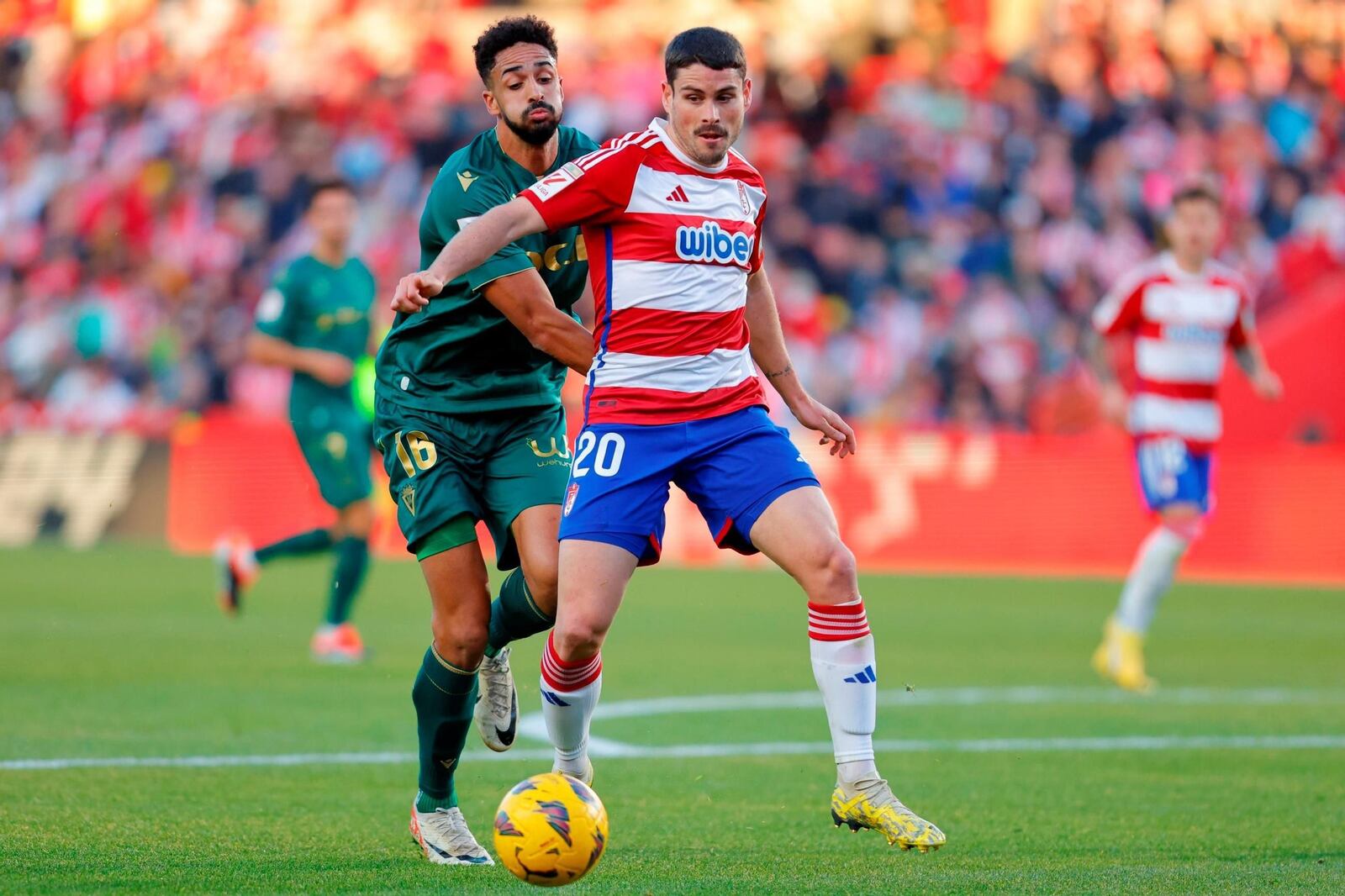 Chris Ramos of Cadiz CF and Sergio Ruiz of Granada CF in action during the Spanish league, La Liga EA Sports, football match played between Granada CF and Cadiz CF at Nuevo Los Carmenes stadium on January 3, 2024, in Granada, Spain. AFP7 03/01/2024 ONLY FOR USE IN SPAIN