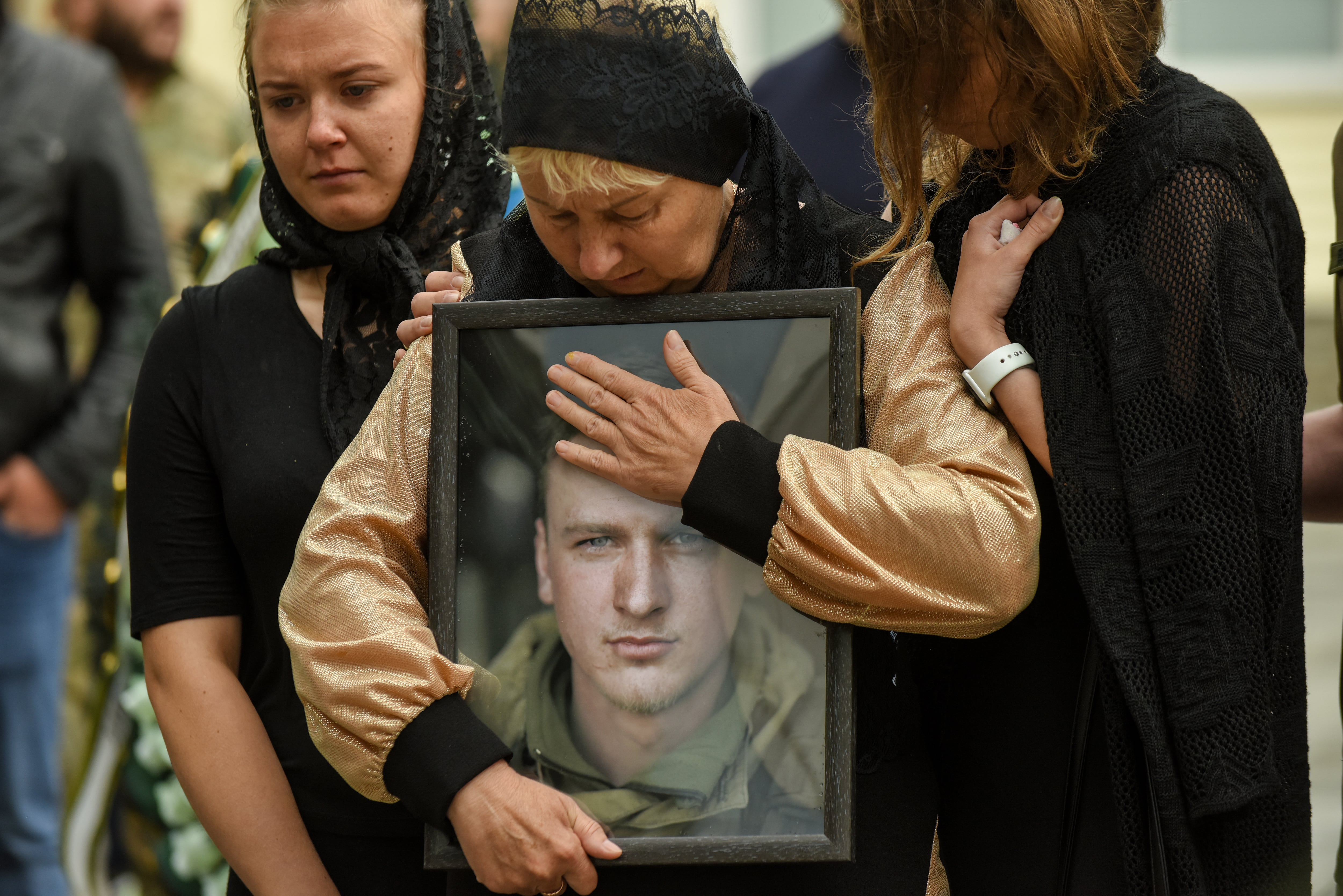 La madre del soldado Andrii Verkhoglyad sujeta un retrato de su hijo durante la ceremonia de su funeral, en Kiev, el pasado 8 de julio (EFE/EPA/OLEG PETRASYUK).