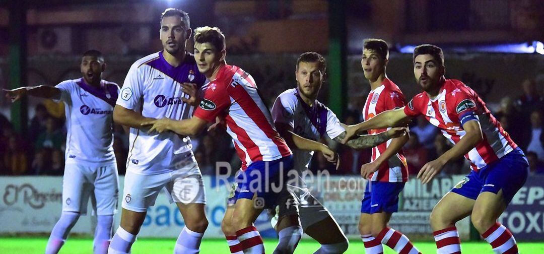 Jugadores del Torredonjimeno y del Real Jaén pelean por un balón en un saque de esquina.