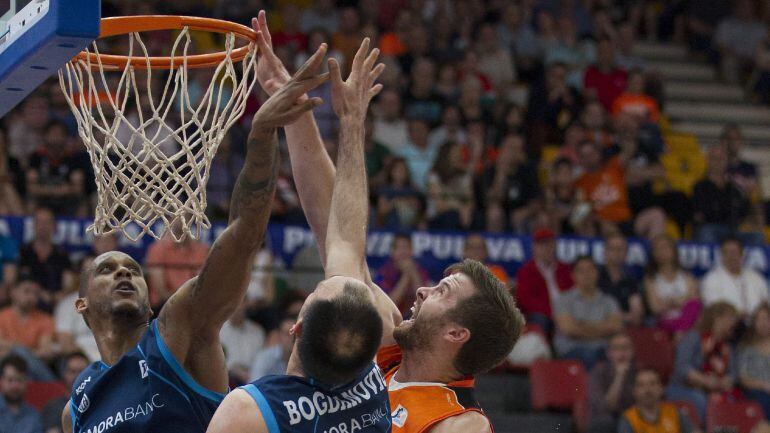 GRA044 VALENCIA, 22-05-2016.- El jugador de Valencia Basket John William Shurna (d) y Joao Gomes &quot;Betinho&quot; y Luka Bogdanovic, del Morabanc Andorra, saltan por una pelota durante el partido de la trigésimo cuarta jornada de la fase regula de la Liga ACB de