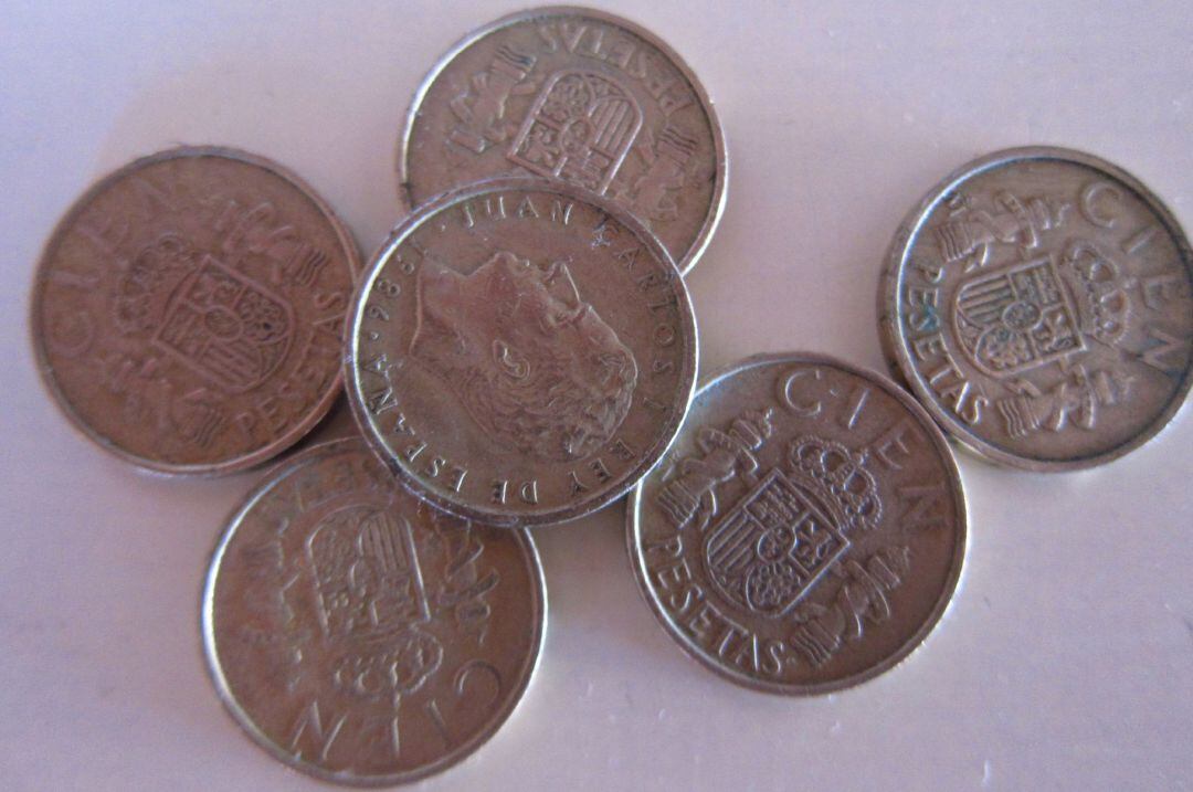 Pesetas de cien en una mesa.