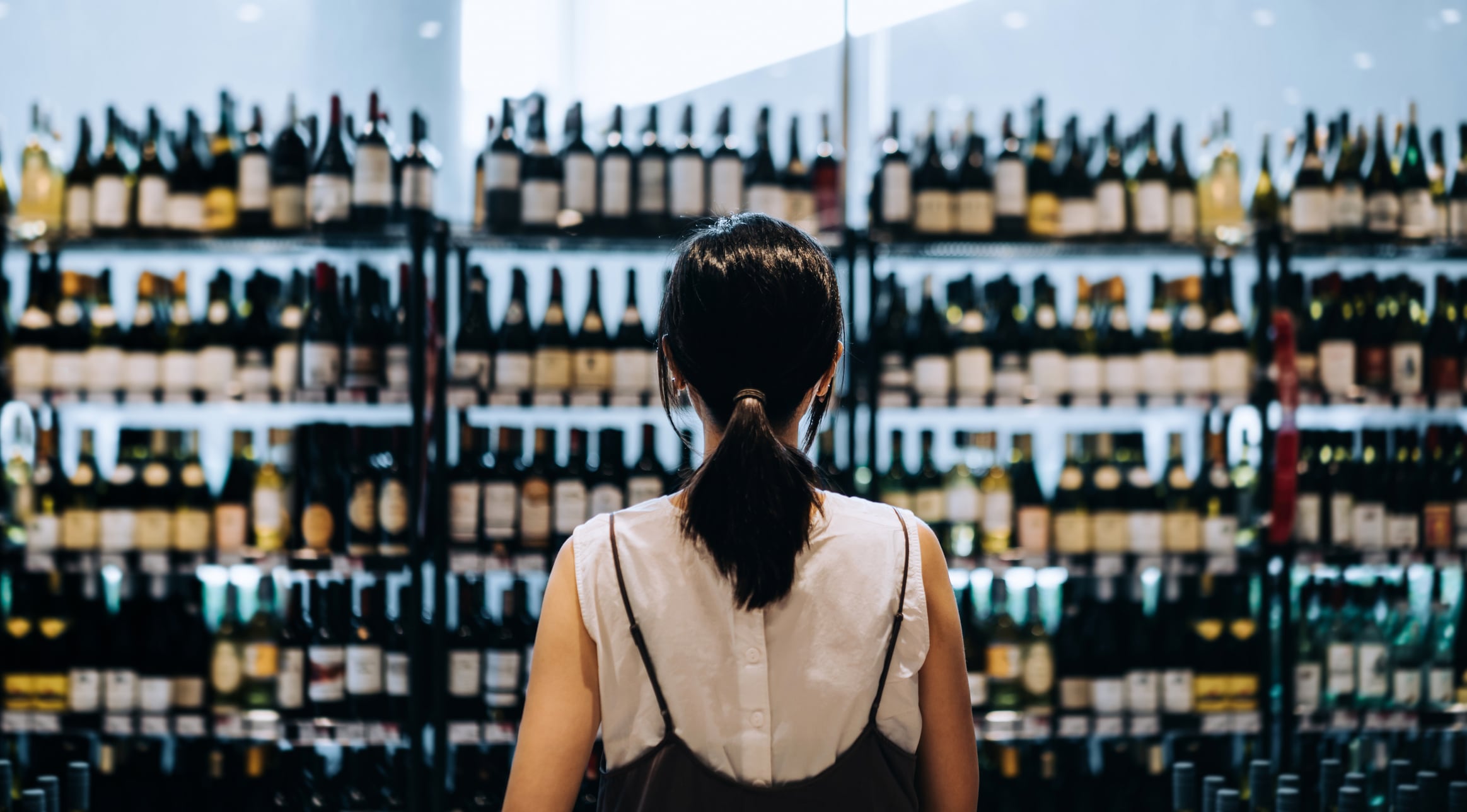 Una mujer, ante la sección de vinos del supermercado.