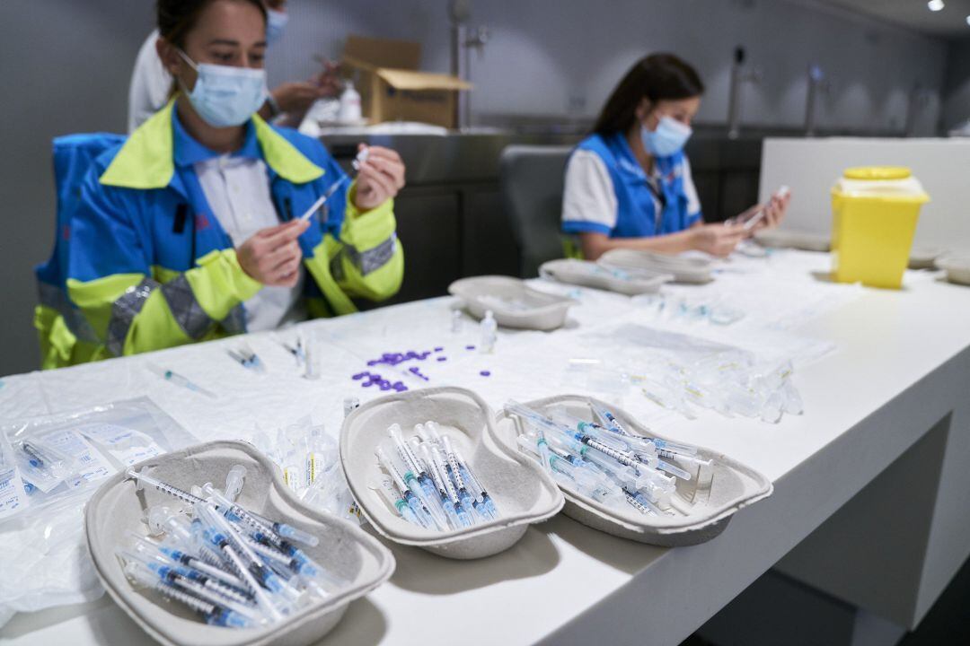 Varios sanitarios preparan las vacunas de la dosis de Pfizer en el Wanda Metropolitano de Madrid