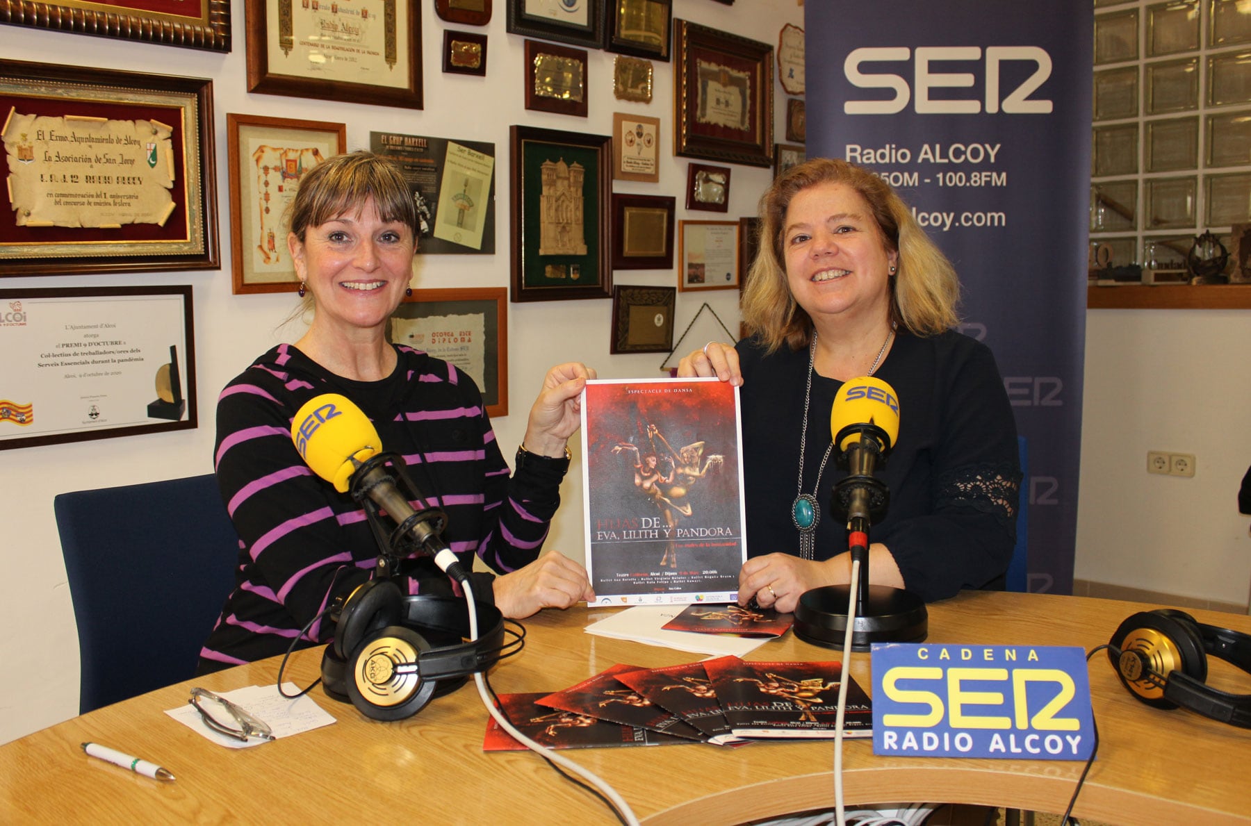 Ana Calvo y la concejal de Igualdad y Políticas Inclusivas, Aranza de Gracia, sostienen un cartel de esta propuesta cultural, en el estudio central de Radio Alcoy
