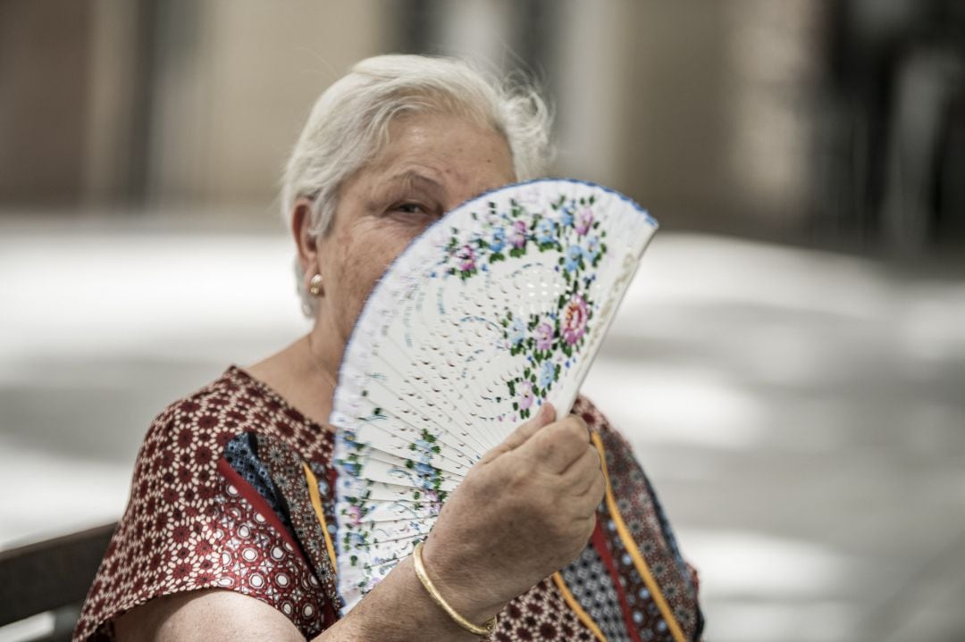 Una mujer agita su abanico para refrescarse