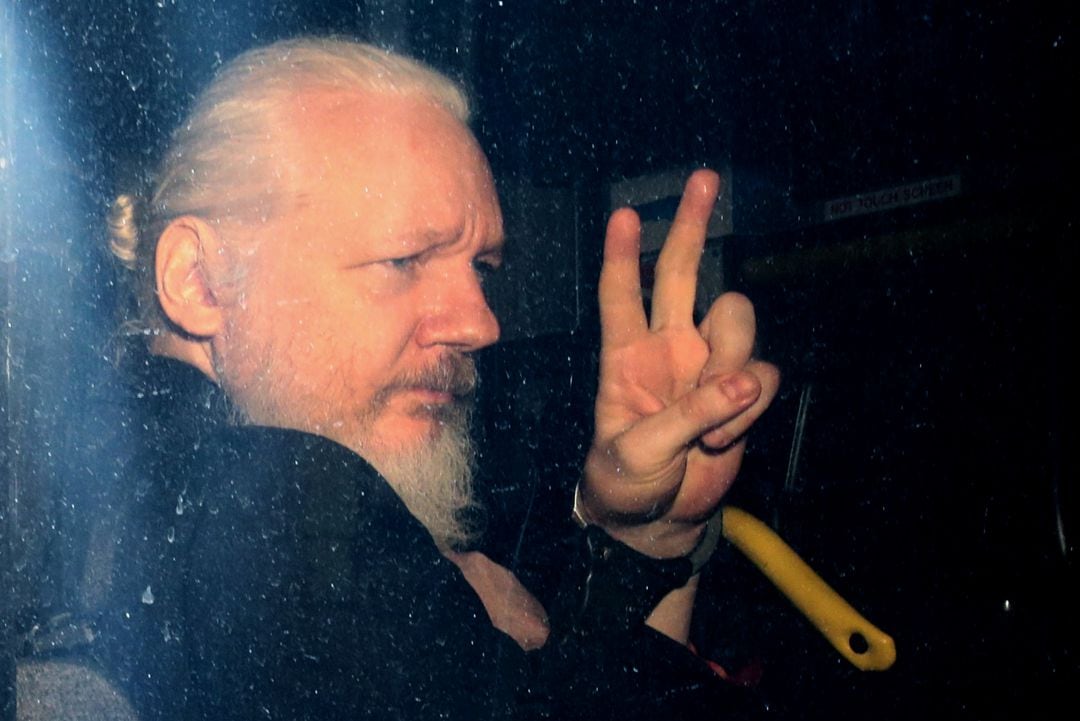 Julian Assange saluda a la prensa desde un vehículo policial durante su llegada a la corte de Westminster en 11 de April de 2019 