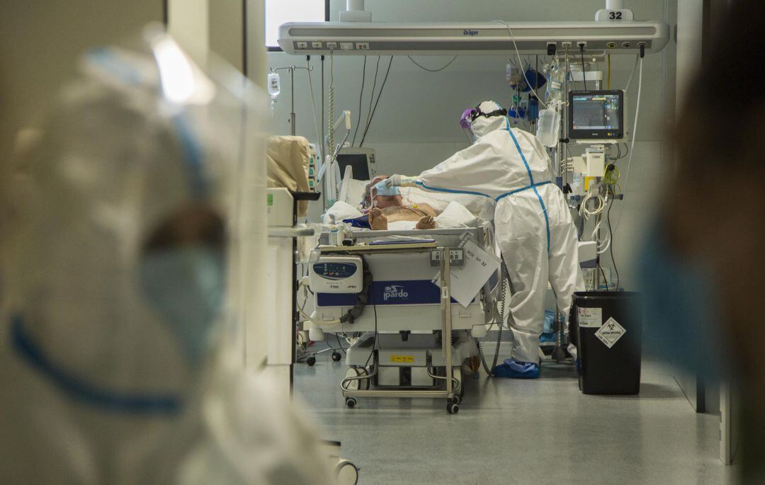 Un paciente de COVID-19 en la UCI atendido por personal sanitario. 