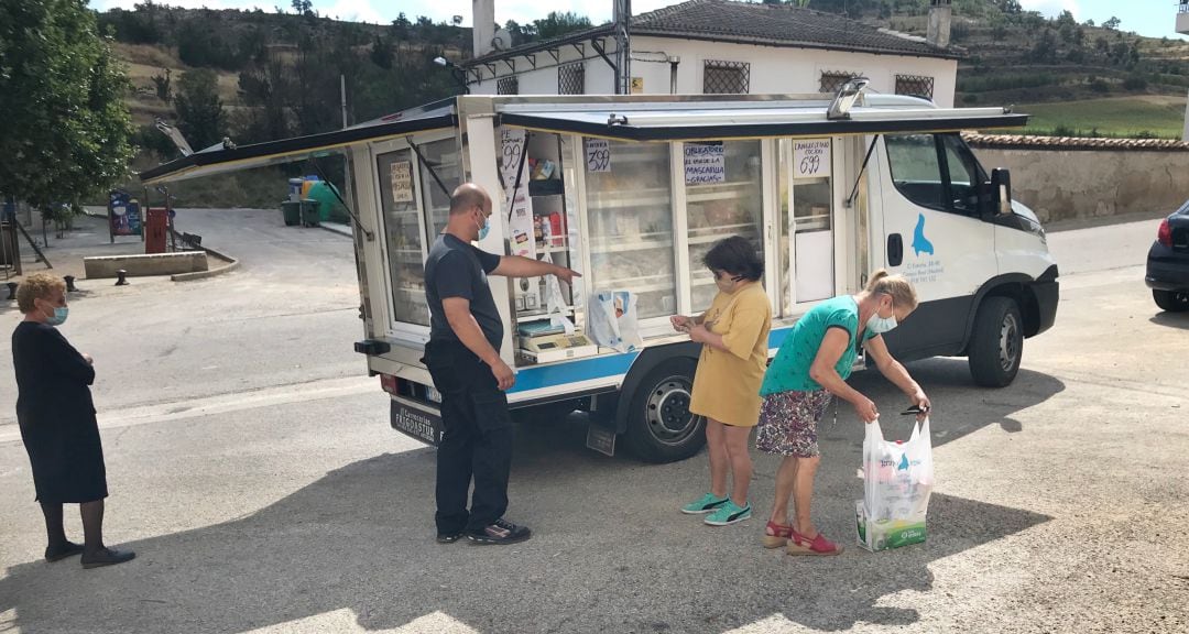 Emiliano García, de Congelados Egea, atiende en su camión de venta ambulante a Ernesta y Rocío, vecinas de Ribagorda, en Sotorribas (Cuenca).