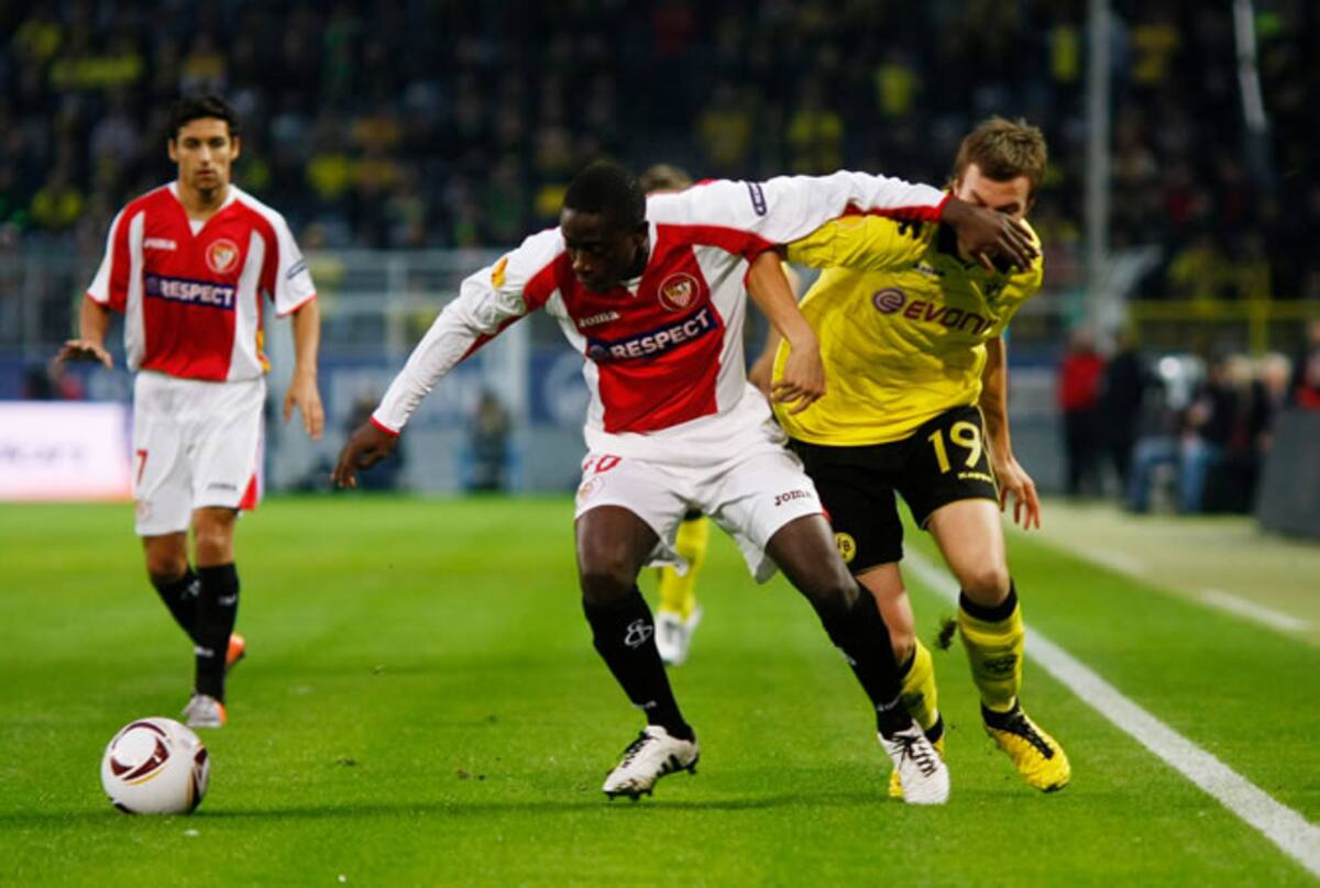 El sevillista Mouhamadou Dabo protege la pelota ante el jugador del Borussia Dortmund Kevin Grosskreutz