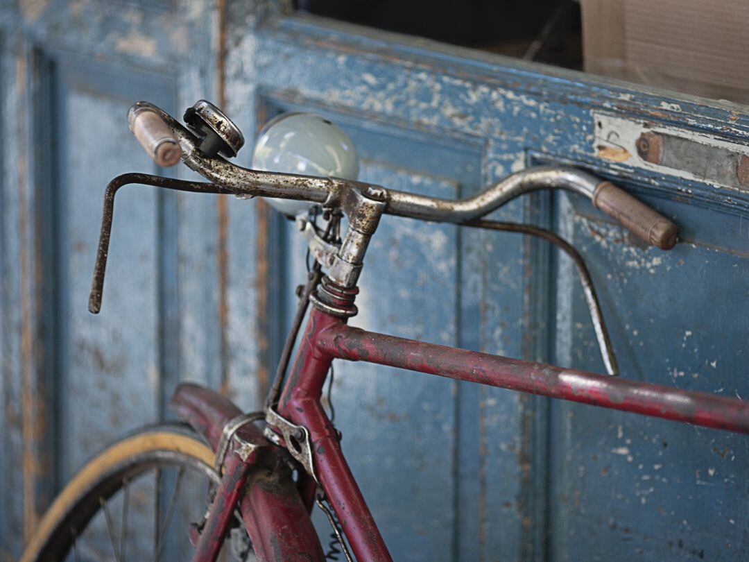 Una bicicleta apoyada en uan puerta. 