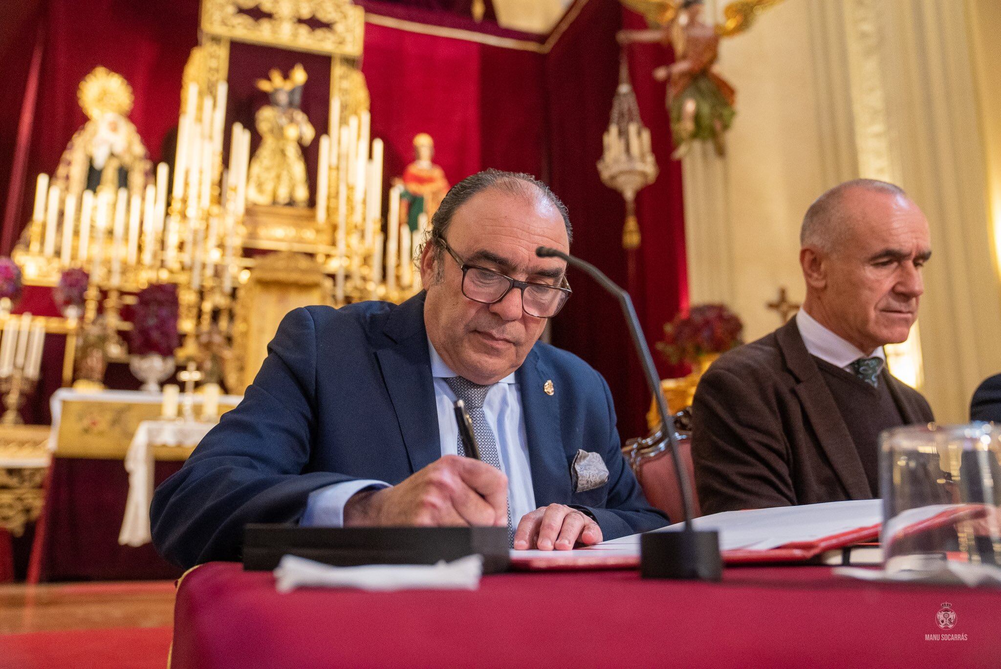 El hermano mayor de Los Gitanos, José María Flores Vargas, procede en presencia del alcalde de Sevilla, Antonio Muñoz, a la firma del documento