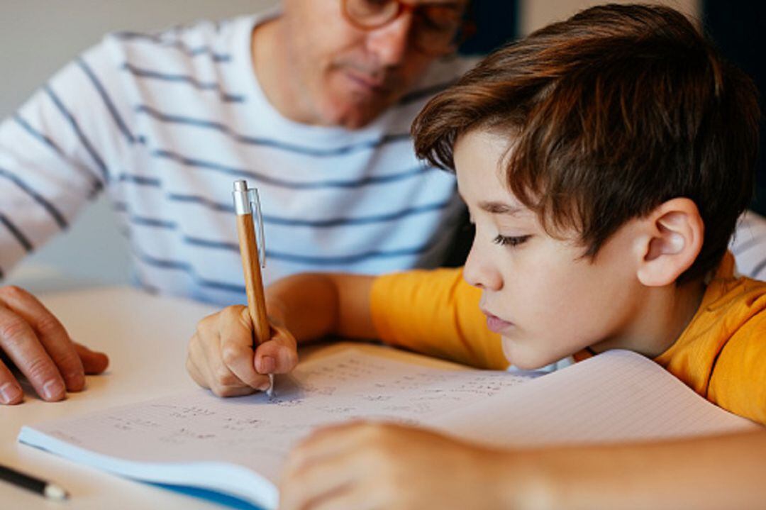 Padre e hijo estudiando en casa 